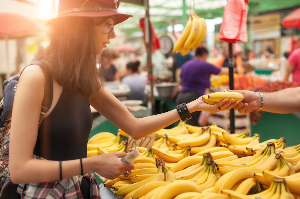Woman looking at bananas at farmers market